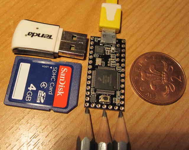 size comparison of the Teensy 3.0 and an SD card, wifi dongle, 2 pence piece and 3 pencils. Top view
